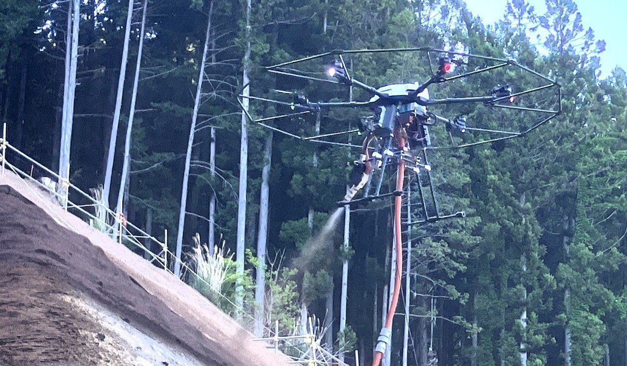 世界初　東興ジオテックとエアロセンス 大型有線給電ドローンによる植生基材吹付工を現場導入